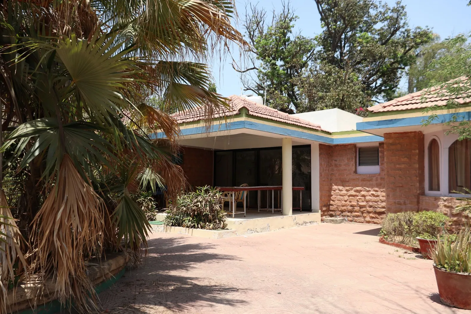 A shaded traditional Indian home surrounded by greenery in Ahmedabad