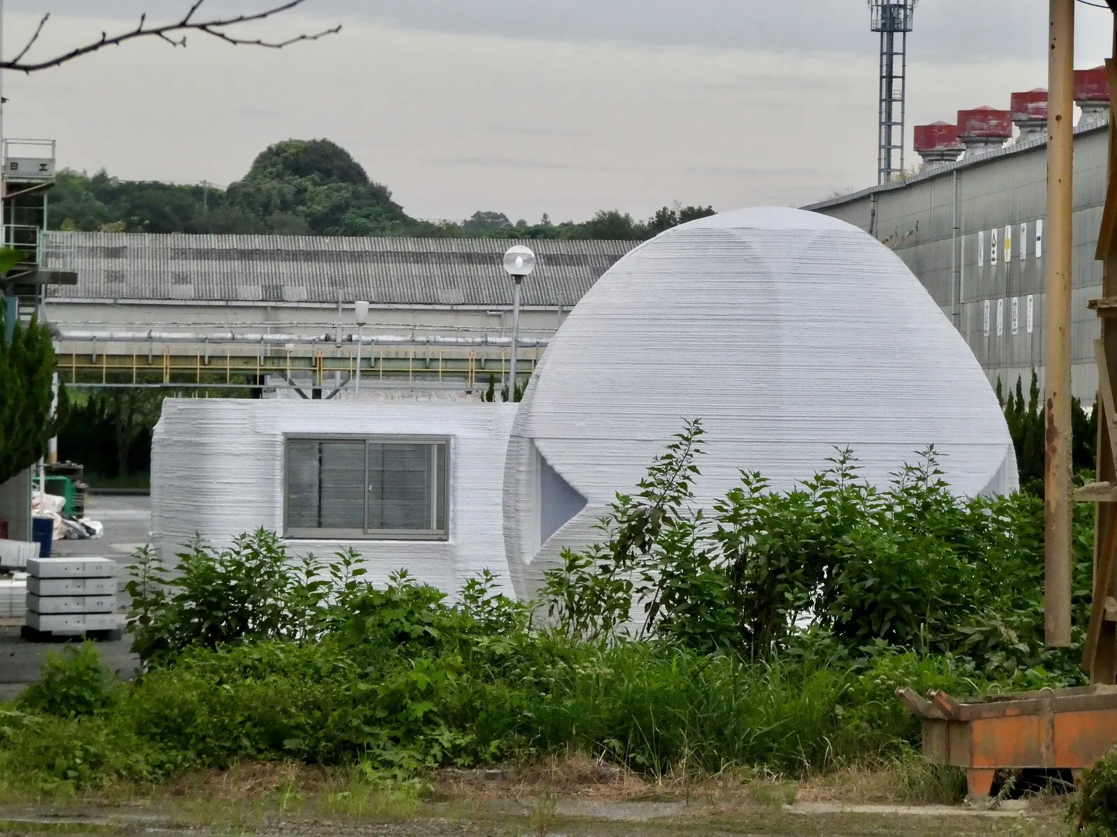 A white 3D-printed house photographed in Aichi, Japan.